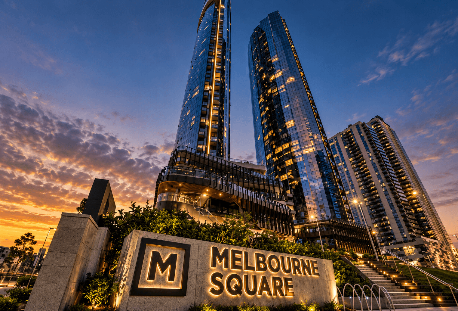 Iconic illuminated Melbourne Square twin towers and landscaped park entrance