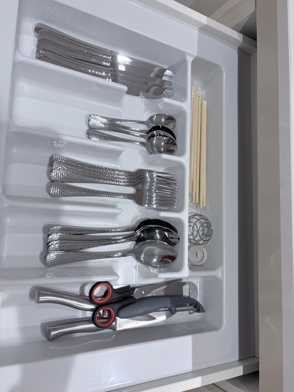 Organized designer kitchen drawer with stainless steel cutlery and cooking tools